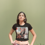 latina-girl-wearing-a-crop-top-tee-template-against-a-solid-color-wall-a19530