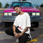 stanley-stella-tee-mockup-of-a-tattooed-man-posing-in-front-of-a-muscle-car-m36828